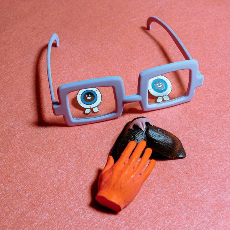 branding glasses on a pink background, and a hand touching a heart that signifies marketing in bahrain