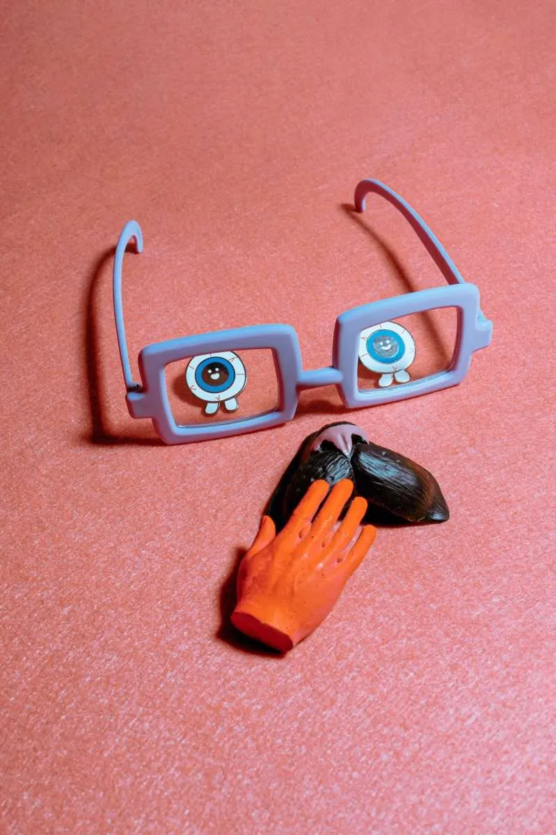 branding glasses on a pink background, and a hand touching a heart that signifies marketing in bahrain